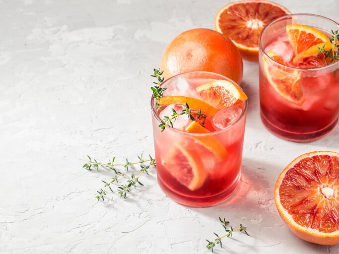 Zwei Gläser mit Campari Spritz auf hellem Untergrund. | © Shutterstock/UliAb