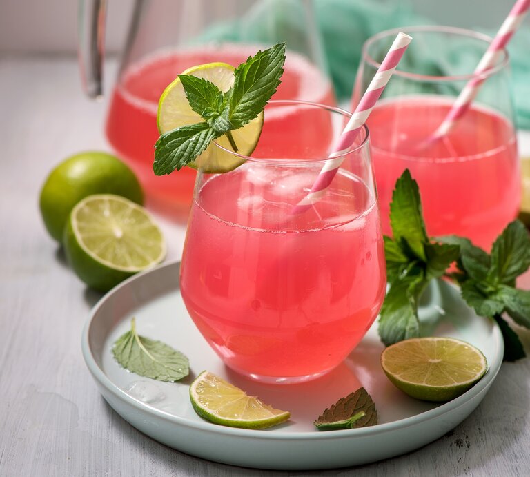 Zwei Gläser Rhabarber-Holunder-Spritz mit Strohhalmen, Minze und Limettenscheiben. | © Adobe Stock/ Sa Scha