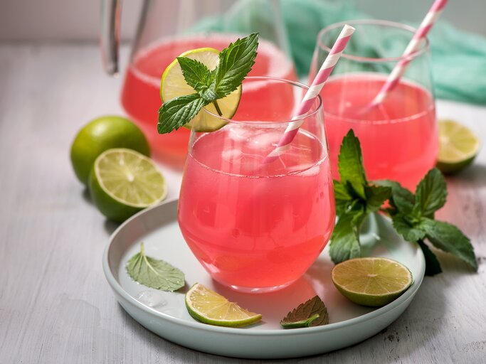 Zwei Gläser Rhabarber-Holunder-Spritz mit Strohhalmen, Minze und Limettenscheiben. | © Adobe Stock/ Sa Scha