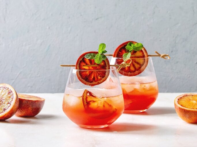 Zwei Gläser Sarti Spritz mit Orangenscheiben dekoriert. | © Adobe Stock/ Natasha Breen