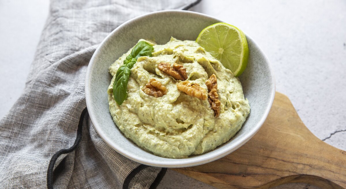 Schale mit Feta-Avocado-Creme mit Walnuss auf hellem Untergrund. 