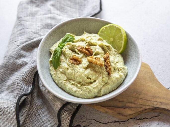 Schale mit Feta-Avocado-Creme mit Walnuss auf hellem Untergrund.  | © Getty Images/lacaosa