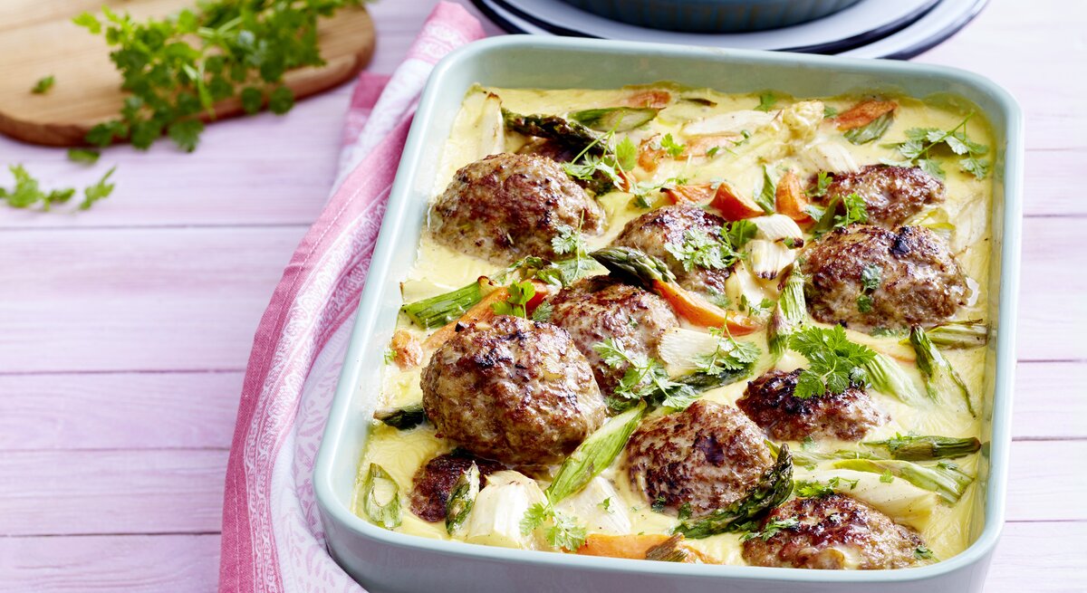 Spargel-Topf mit Frikadellen in Auflaufform serviert.