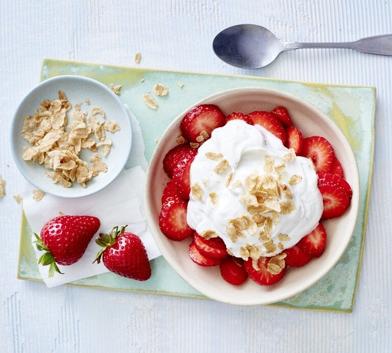 In einer Schüssel sind Erdbeeren mit Vanillequark angerichtet. Darüber sind Dinkel-Flocken gegeben.  | © EATCLUB / Isabell Triemer