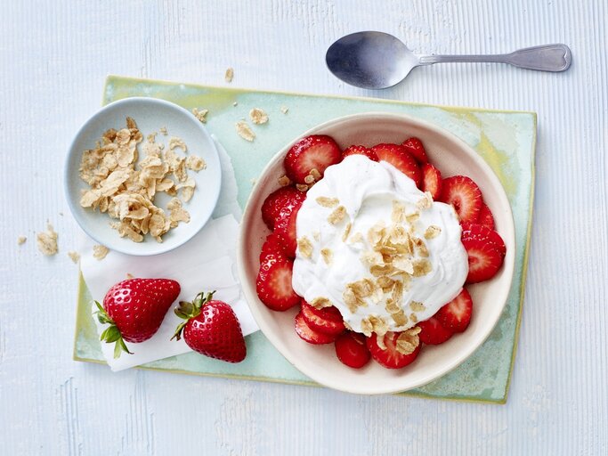 In einer Schüssel sind Erdbeeren mit Vanillequark angerichtet. Darüber sind Dinkel-Flocken gegeben.  | © EATCLUB / Isabell Triemer