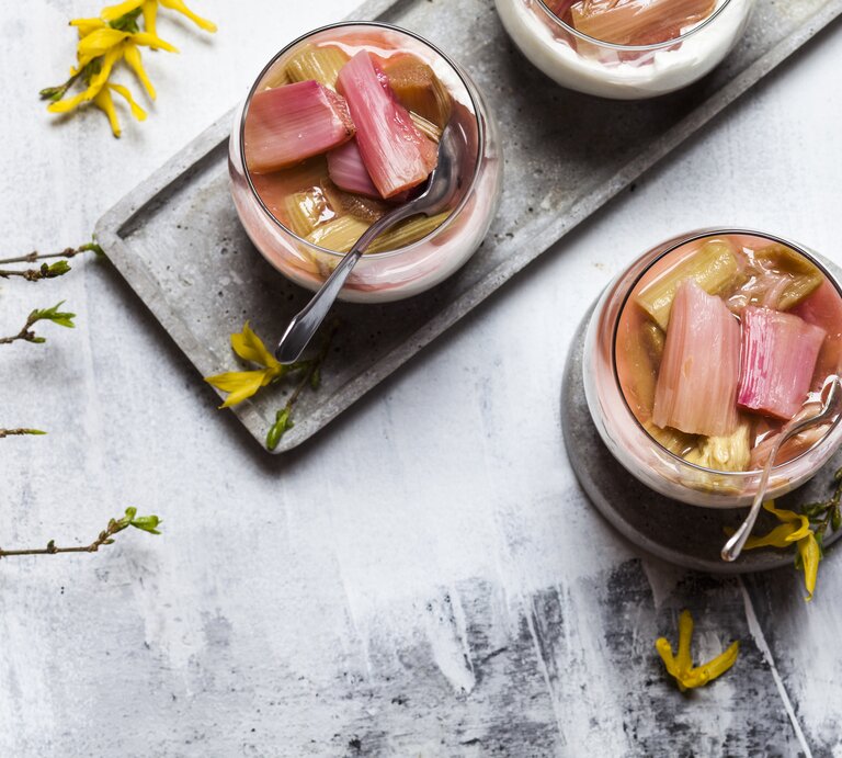 Rhabarber-Quark-Dessert im Glas auf hellem Untergrund in frühlingshaftem Ambiente.  | © Getty Images/Westend61