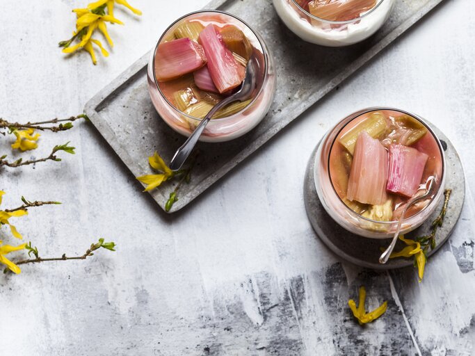 Rhabarber-Quark-Dessert im Glas auf hellem Untergrund in frühlingshaftem Ambiente.  | © Getty Images/Westend61