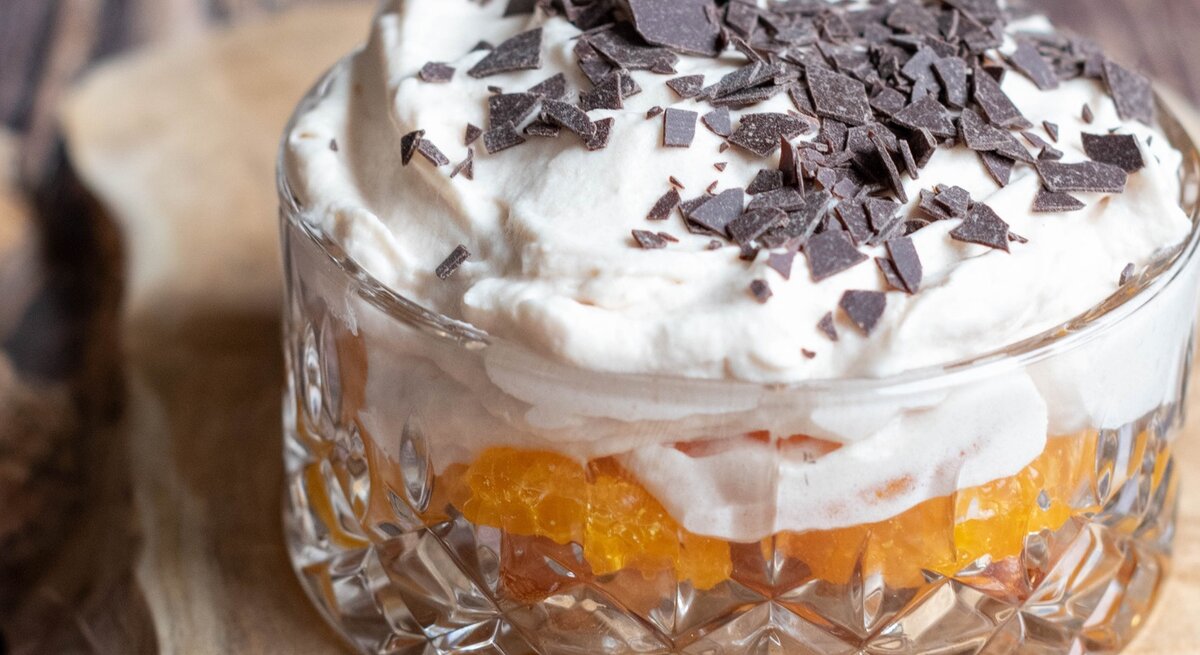 Dessert mit Löffelbiskuit und Mandarine auf Holz