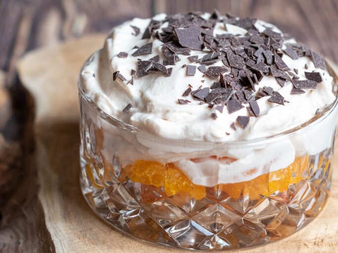 Dessert mit Löffelbiskuit und Mandarine auf Holz | © Getty Images/Marie Wurm