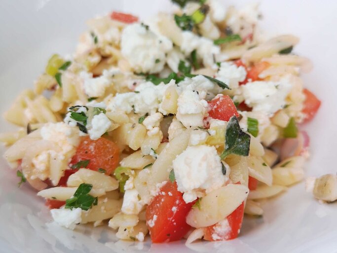 Griechischer Nudelsalat mit Feta, Melone, Tomate und Oliven auf weißem Teller.  | © privat
