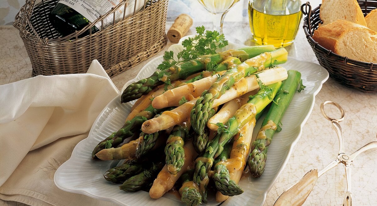 Weißer und grüner Spargel auf einem weißen Servierteller. 