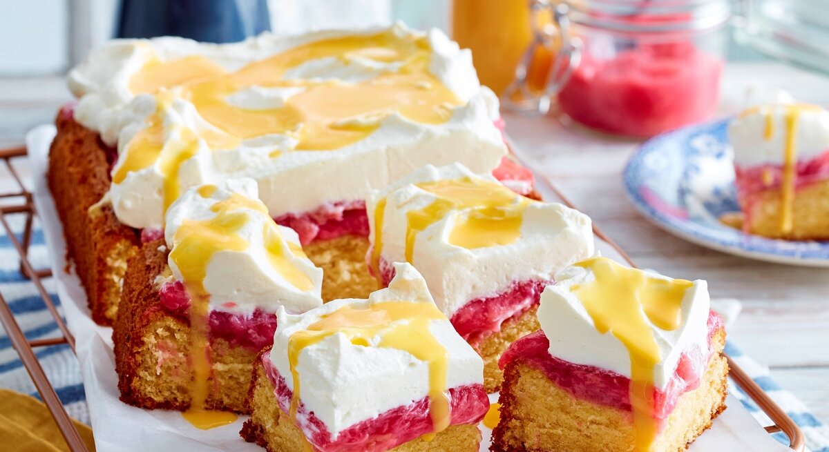 Auf einem Blech ist eine Eierlikör-Rhabarbertorte seriert. Sie ist mit Eierlikör beträufelt.