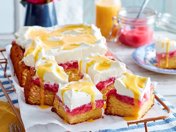 Auf einem Blech ist eine Eierlikör-Rhabarbertorte seriert. Sie ist mit Eierlikör beträufelt. | © EAT CLUB / Isabell Triemer