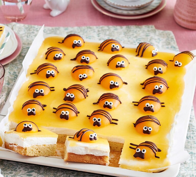 Auf einem Kuchenblech ist ein Käfer-Kuchen angerichtet. Er ist mit kleinen Käfern aus Aprikosen verziert. | © EAT CLUB / Isabell Triemer