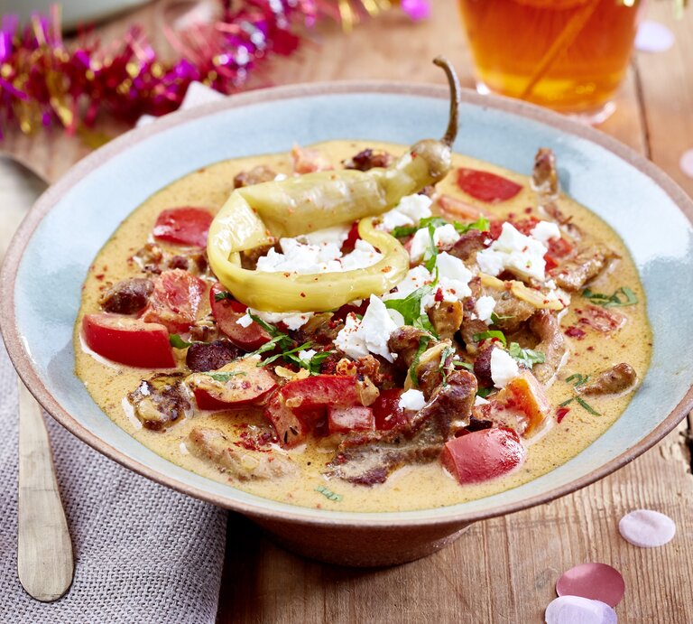 Ein Teller Gyrossuppe mit Feta, drumherum etwas Partydeko. | © EAT CLUB/ Isabell Triemer