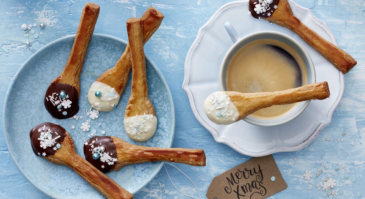 Spekulatius-Löffel-Plätzchen auf blauen Tellern auf blauem Untergrund. 