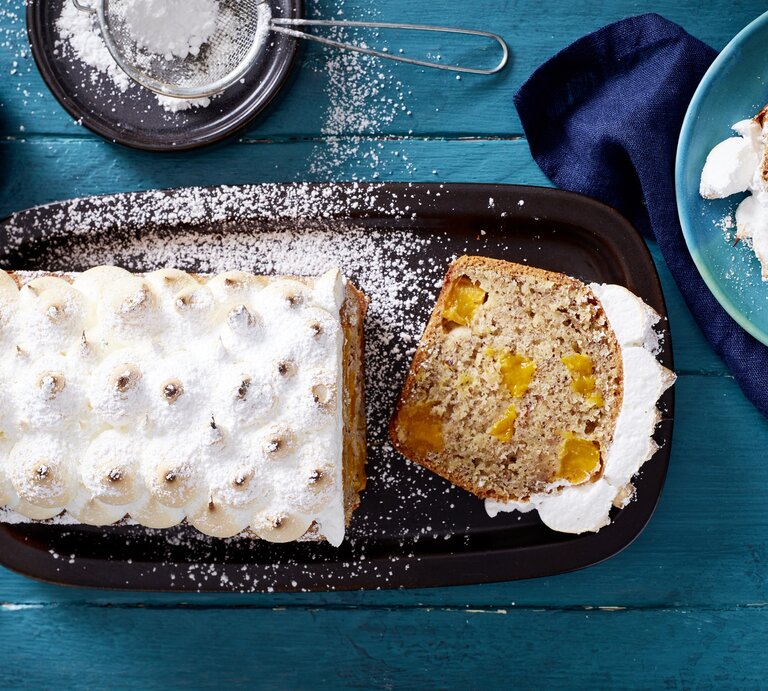 Der Mango-Baiser-Kuchen direkt von oben auf einem blauen Holztisch fotografiert. | © EAT CLUB/Isabell Triemer