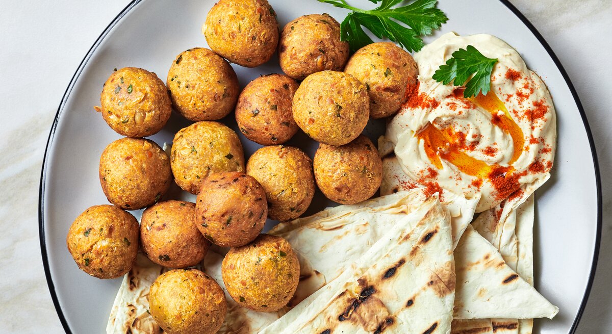 Frittierte Topinambur-Bällchen mit Hummus und Fladenbrot.