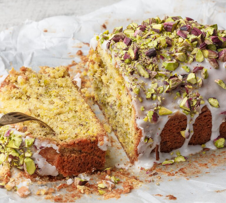 Ein angeschnittener Pistazien-Zitronenkuchen aus der Kastenform. | © Shutterstock/ anna.q