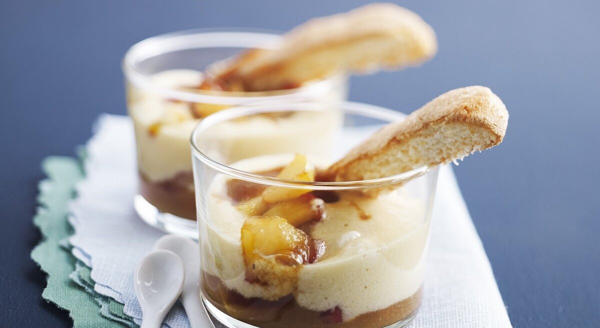 In zwei Gläsern ist ein Dessert nach Tiramisu-Art mit Apfel und Apfelwein angerichtet. 