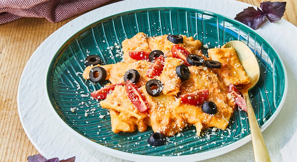 Rigatoni-Thunfisch-Auflauf mit schwarzen Oliven auf Teller serviert.