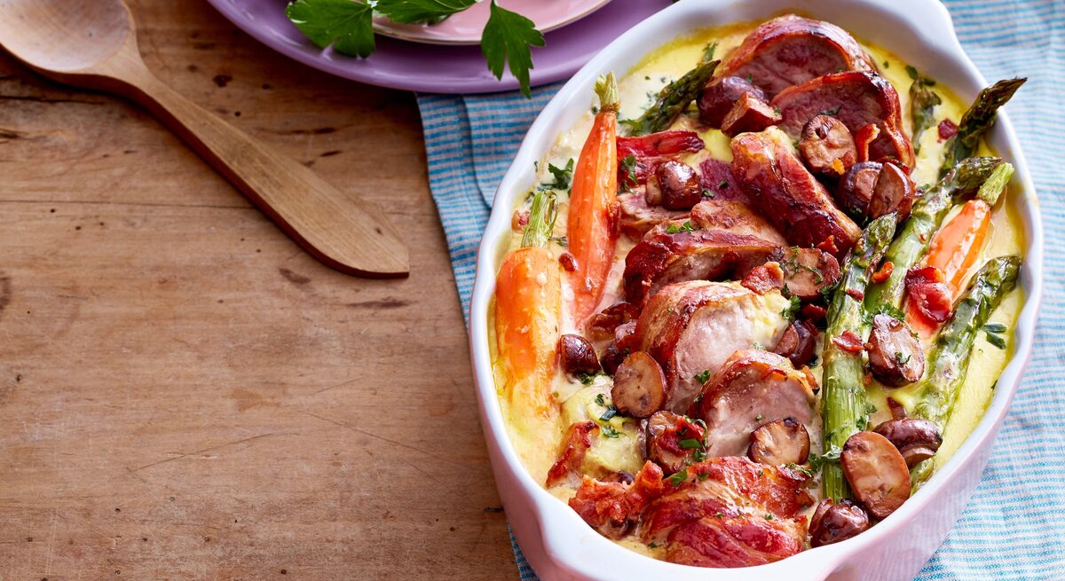 Schweinefilet mit Spargel-Gemüse in Auflaufform auf dem Tisch serviert.