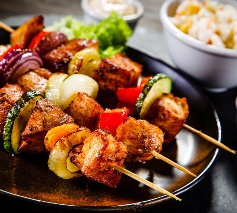 Saftig-zarte Schweinefiletspieße mit Gemüse frisch gegrillt auf dem Teller. | © Getty Images/iStockphoto/Jacek Chabraszewski