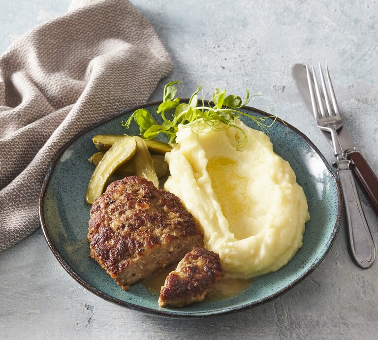 Butterfrikadellen mit Kartoffelpüree auf Teller serviert. | © StockFood / Profimedia