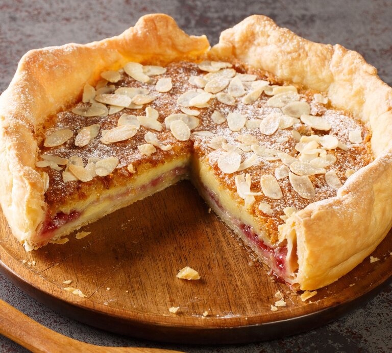 Ein Bakewell-Pudding auf einem Holzbrett auf einem grauem Steintisch. | © Gettyimages/ ALLEKO