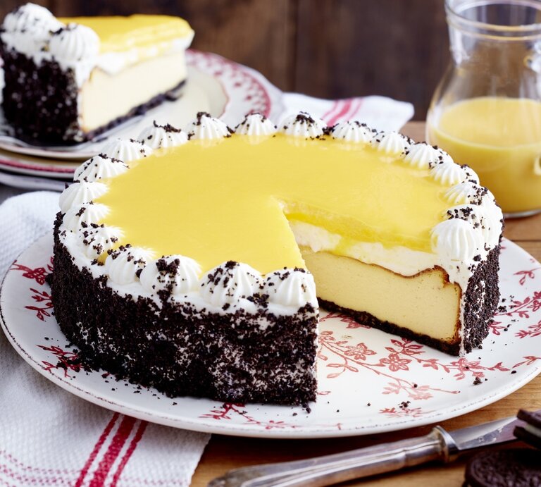 Ein angeschnittener Kakaokeks-Käsekuchen, daneben ein Teller mit einem Stück davon sowie ein Milchkännchen. | © EAT CLUB/ Isabell Triemer