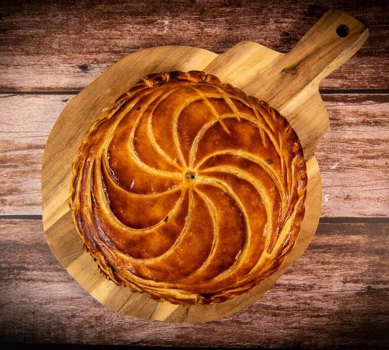 Galette de Rois auf Holzbrett und dunklem Untergrund. Draufsicht. | © Getty Images / Esperanza33