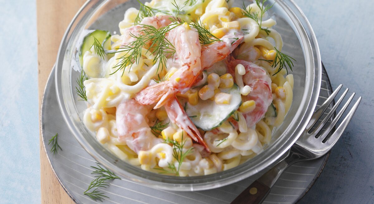 Skandinavischer Nudelsalat mit Gurken und Garnelen / kleine runde Schale aus Glas / Gabel / Nahaufnahme / Draufsicht