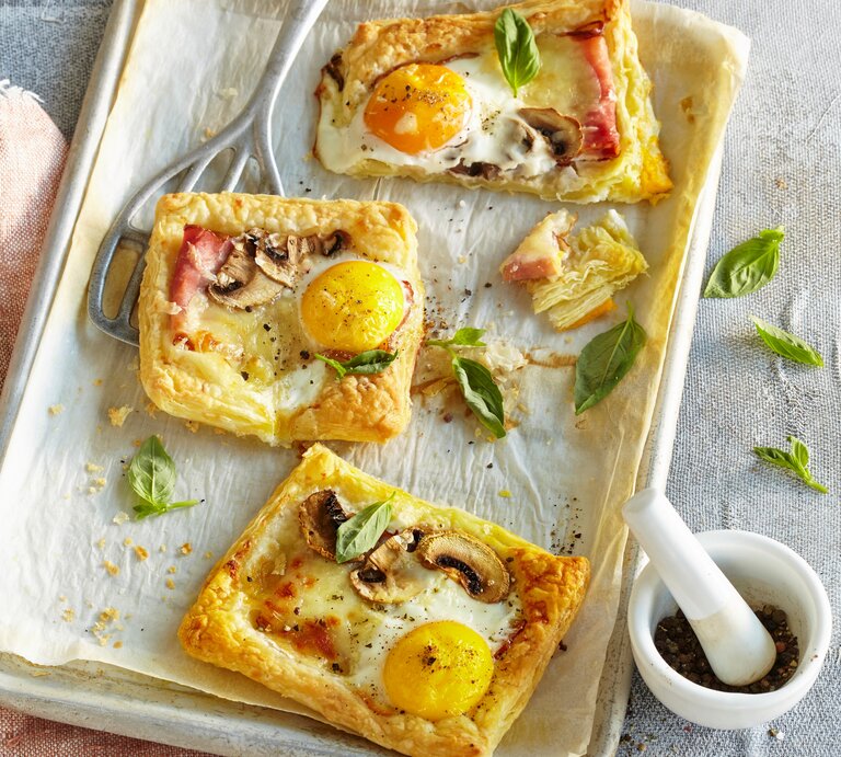 Blätterteigpizzen auf weißem Blech mit Gewürzmörser auf Mikrofaserdecke. | © StockFood / Profimedia