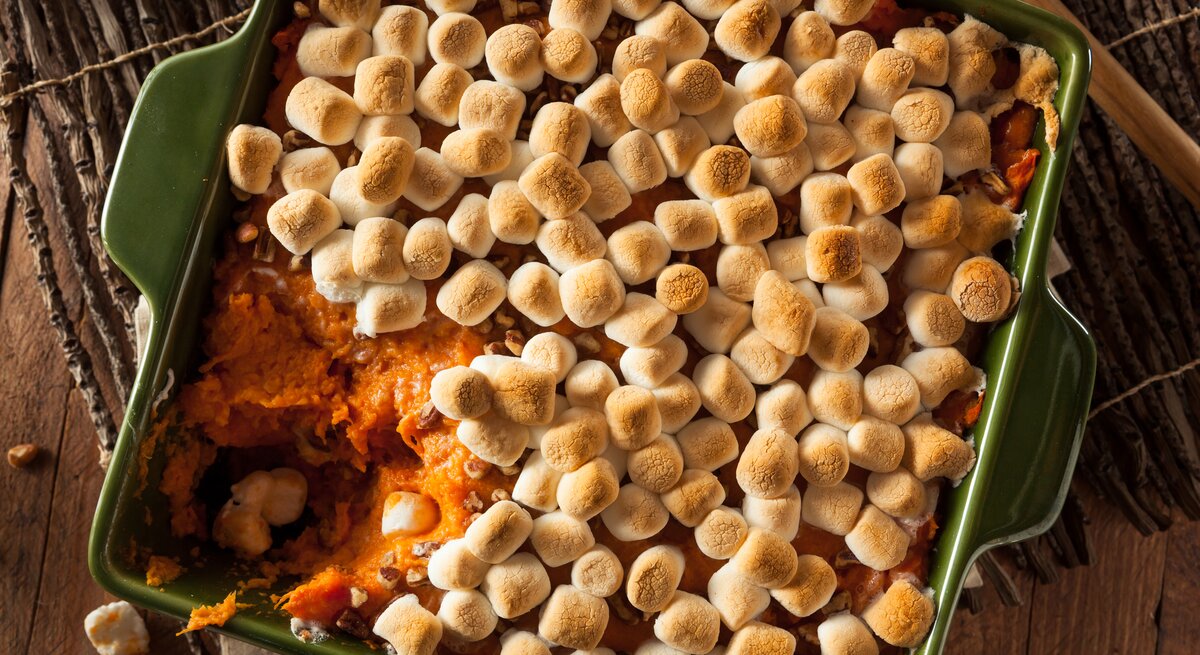 Eine eckige, grüne Auflaufform mit Süßkartoffelauflauf mit Marshmallows in der Draufsicht.
