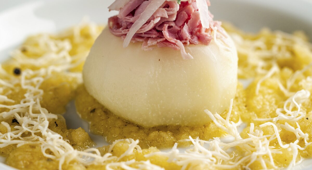 Saftiger gebackener Kohlrabi gefüllt mit Schinken auf einer Kohlsuppe mit Äpfeln, gewürzt mit Currypulver und geriebenem Rettich
