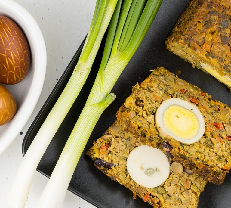 Vegetarischer Braten mit Ei auf einem schwarzen Brett und hellem Untergrund. | © Gettyimages/ by ale_flamy