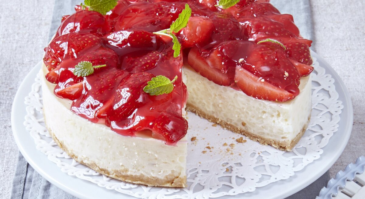 Angeschnittene Milchreistorte mit Erdbeeren und Minzblättern / runde Kuchenplatte / Nahaufnahme Draufsicht | © Carolin Müller