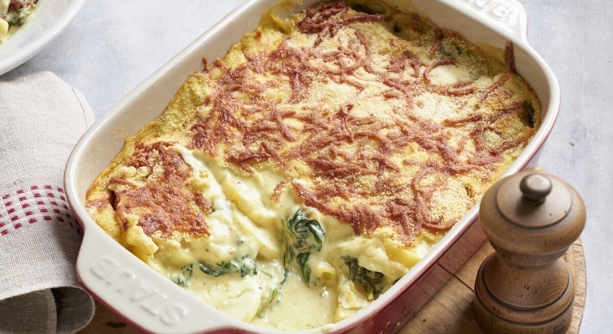 In einer Auflaufform ist ein Eierauflauf mit Senfcreme angerichtet. Er ist mit Käse überstreut. 
