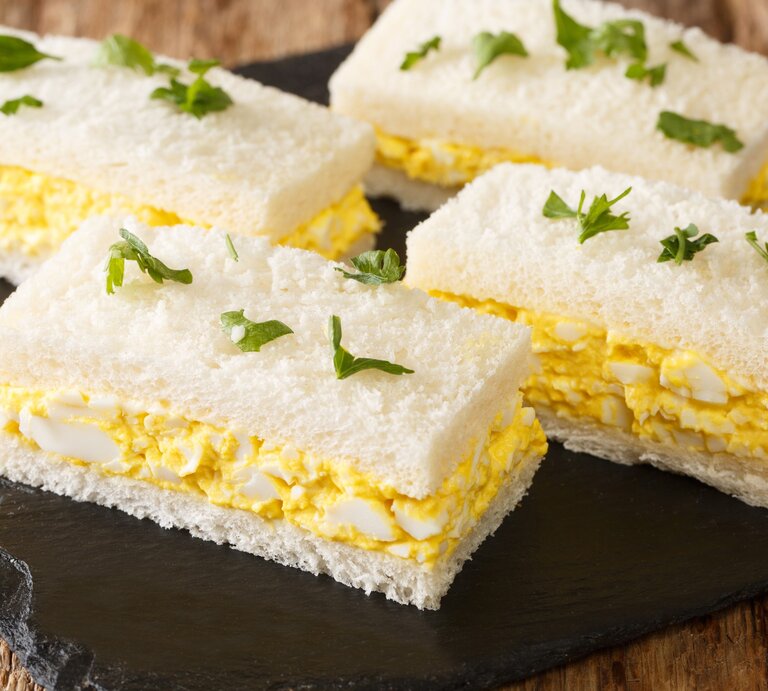 Japanisches Eiersalat-Sandwich auf Schieferplatte auf Holztisch. Draufsicht. | © Getty Images / ALLEKO