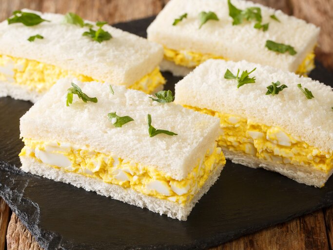 Japanisches Eiersalat-Sandwich auf Schieferplatte auf Holztisch. Draufsicht. | © Getty Images / ALLEKO