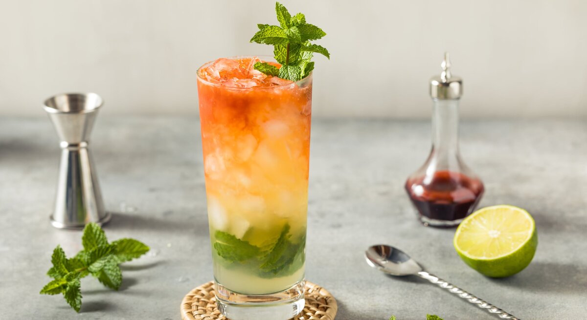 Bunt gemischter Cocktail mit Minze und Eiswürfeln.