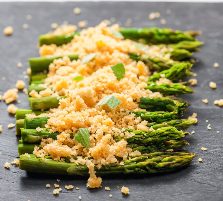 Spargel mit Parmesan-Semmelbröseln auf Schieferplatte. | © Shutterstock/Richard Semik