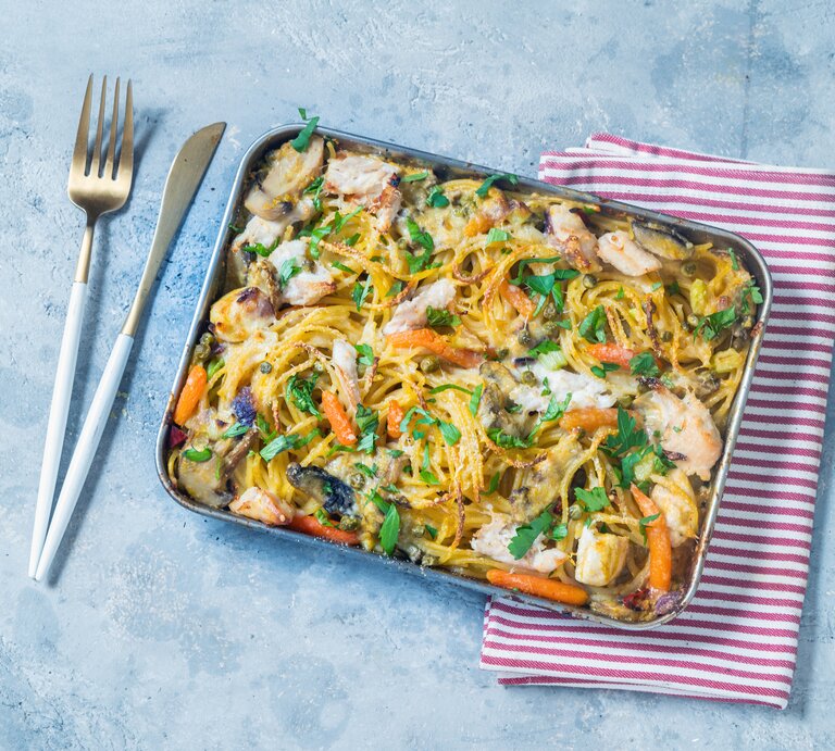 Ein-Blech-Pasta mit Hähnchen: ein Backblech mit Spaghetti, Hähnchen, Pilzen, Möhren und Petersilie. | © Getty Images/ Carlo A