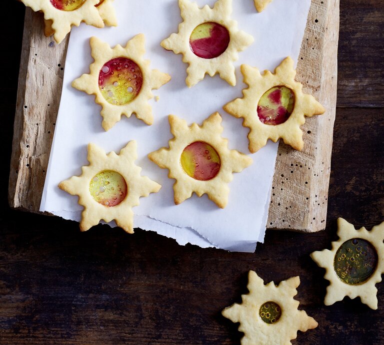 Mehrere Weihnachtssterne mit buntem Zucker liegen auf einem Holzbrett.  | © Isabell Triemer