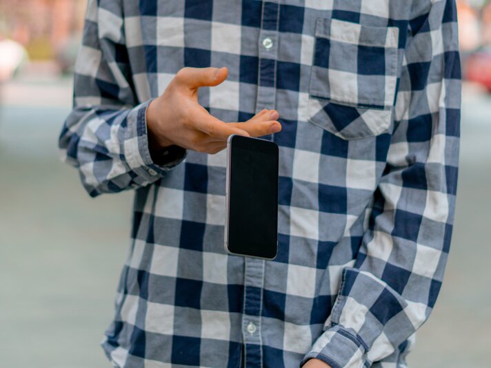 Person fällt Handy aus der Hand. | © Getty Images/Михаил Руденко