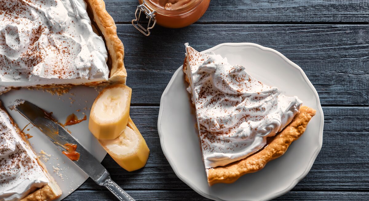 Draufsicht auf eine Torte mit mürbem Boden, Bananen und feiner Creme.