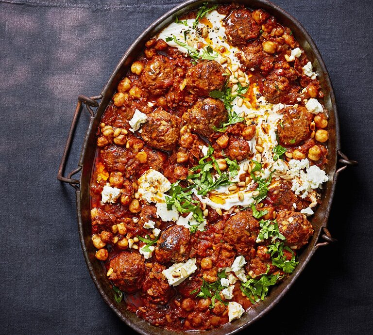 Harissa-Hackbällchen mit Feta-Swirl in einer metallischen Auflaufform. Das Ganze auf einem dunklen Untergrund.  | © StockFood / Immediate Media / Olive