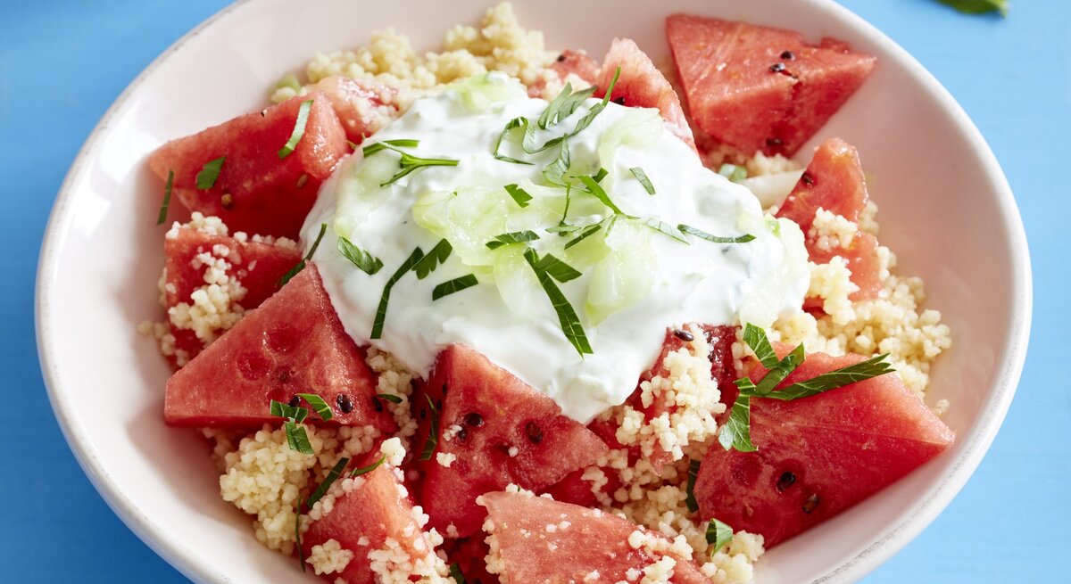 Melonensalat mit Couscous auf Teller serviert.