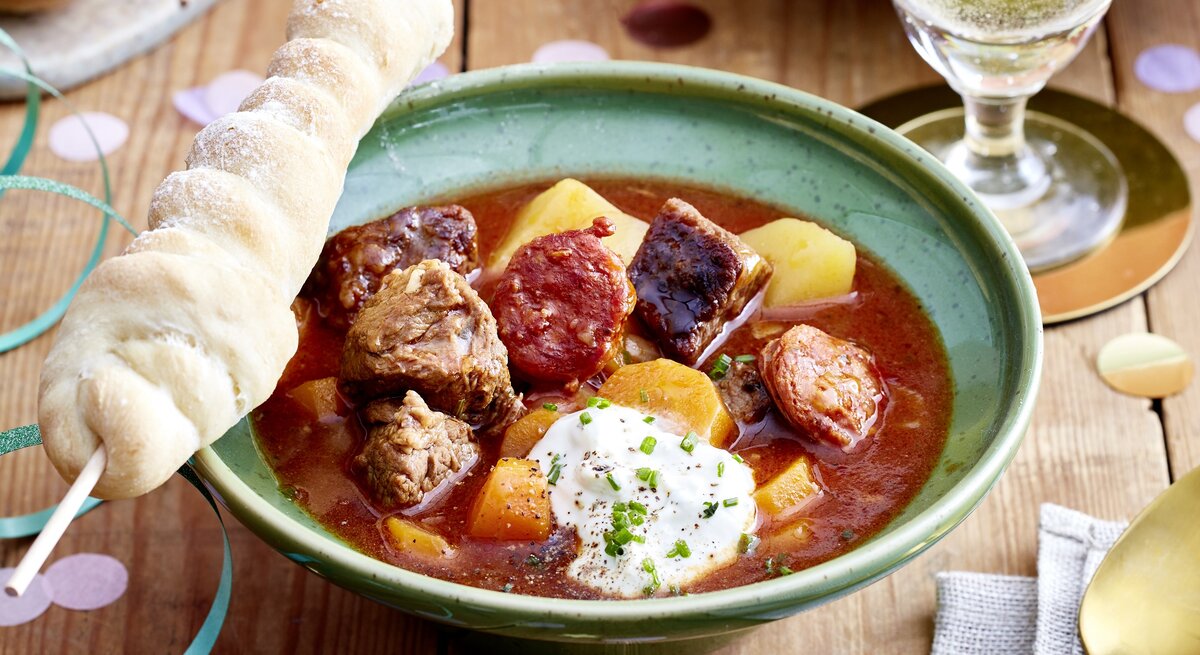 Lagerfeuersuppe mit Stockbrot angerichtet.