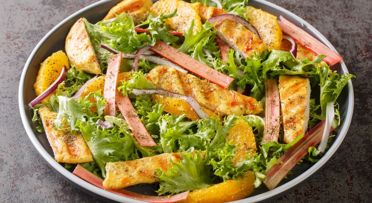 Eine graue Schüssel mit dem Salat auf einem mattgrauen Untergrund.